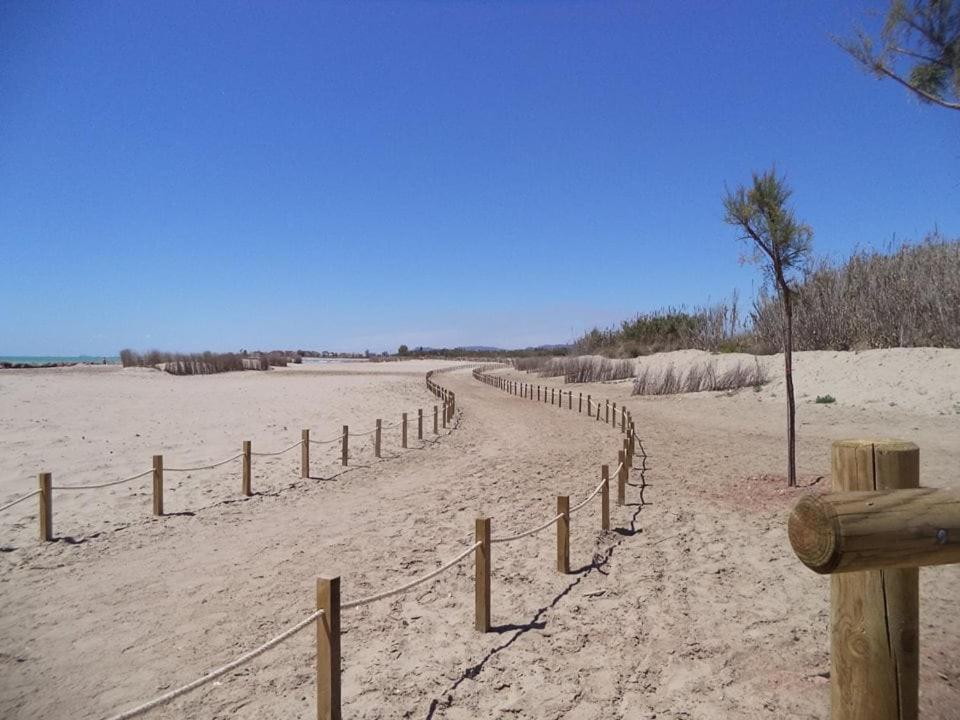 a dirt road on a beach with a fence at Luz del Mediterráneo in Moncófar