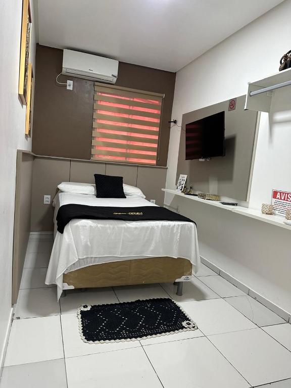 a bedroom with a bed and a television in it at Flat JK 202 in Juazeiro do Norte