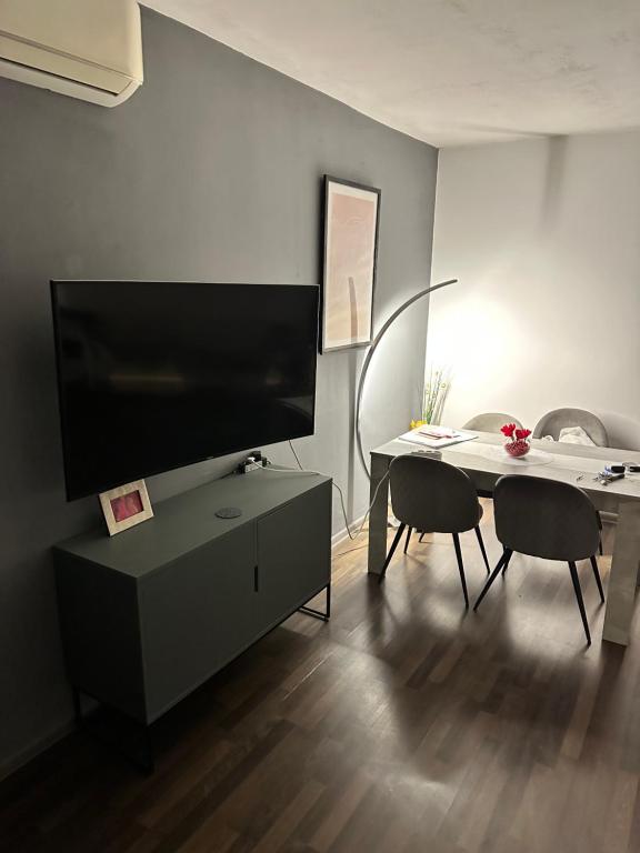 a living room with a tv and a table with chairs at Apartment Zvečaj in Đakovo