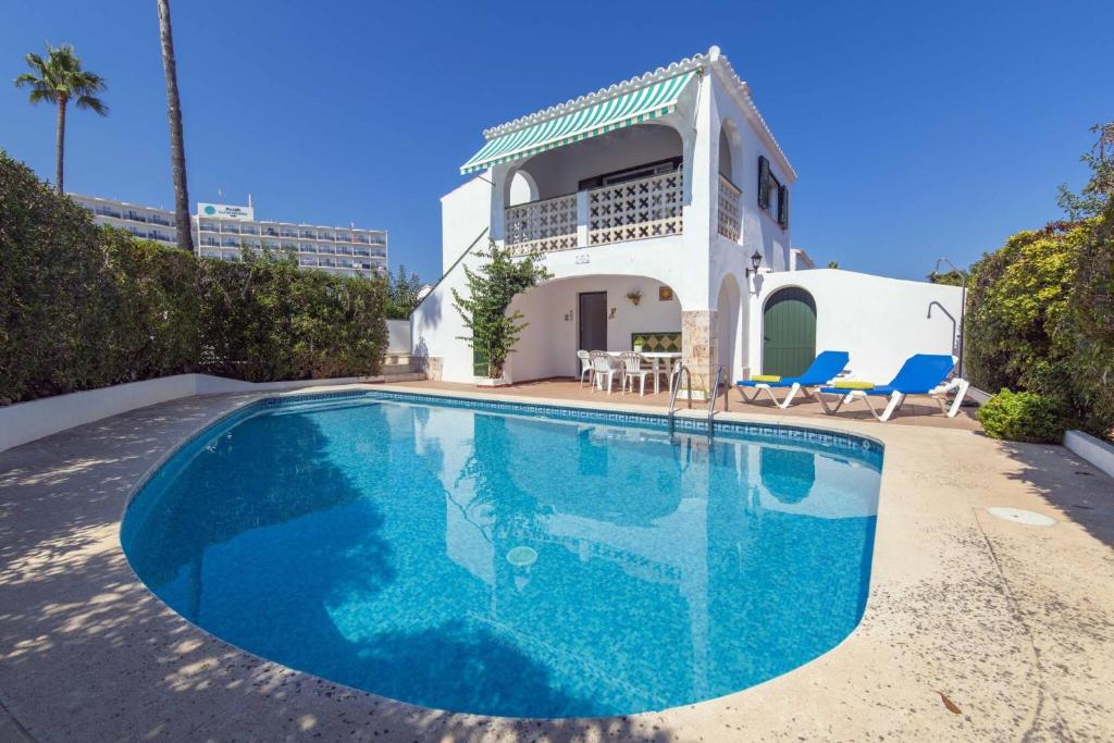 a large blue swimming pool in front of a house at Villa Mare a fabulous hideaway in S'Algar