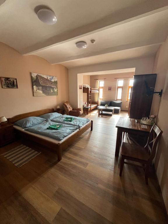 a bedroom with a bed and a living room at Wellness hotel - Viktorka, herecký dům in Česká Skalice