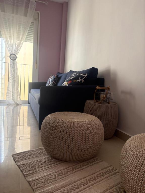 a living room with a couch and a ottoman at Encantador, tranquilo y centrico in Málaga