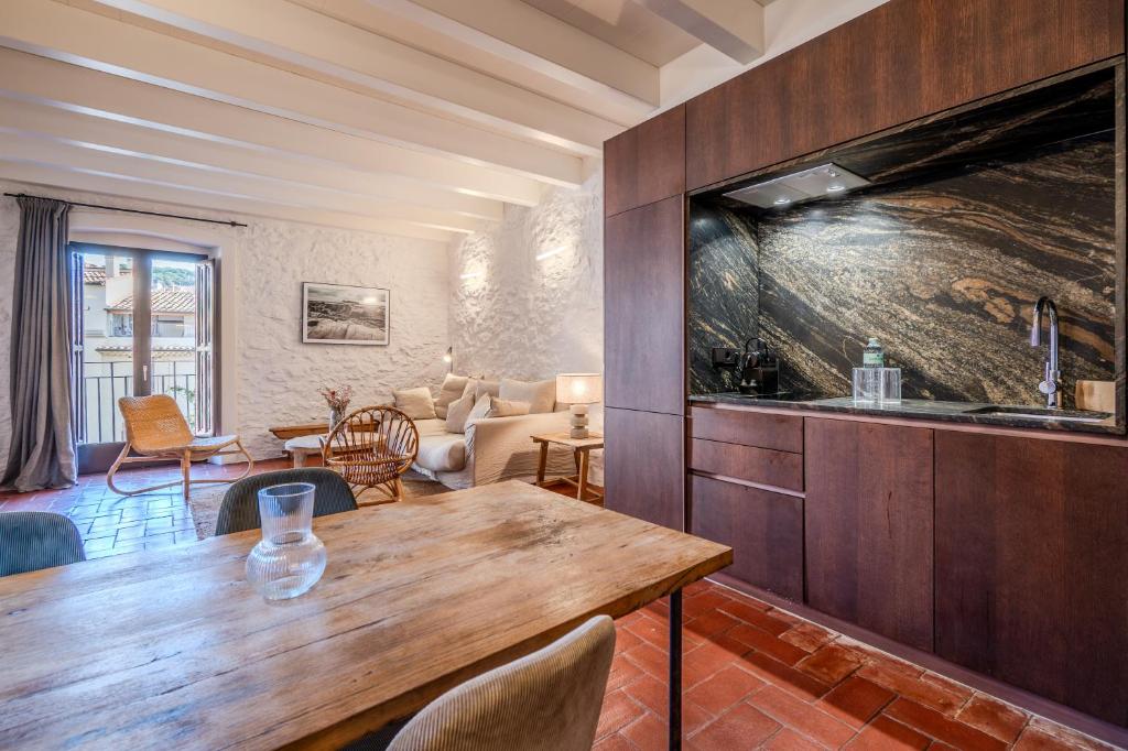a kitchen with a wooden table and a living room at Flateli Santa Clara 21 in Girona