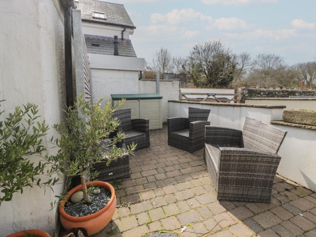 a patio with chairs and a table on a balcony at Awen Ingli in Newport