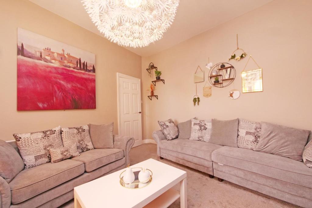 a living room with two couches and a table at Ashville Grange Scarborough Sleeps 10 Large Beautiful House in Scarborough