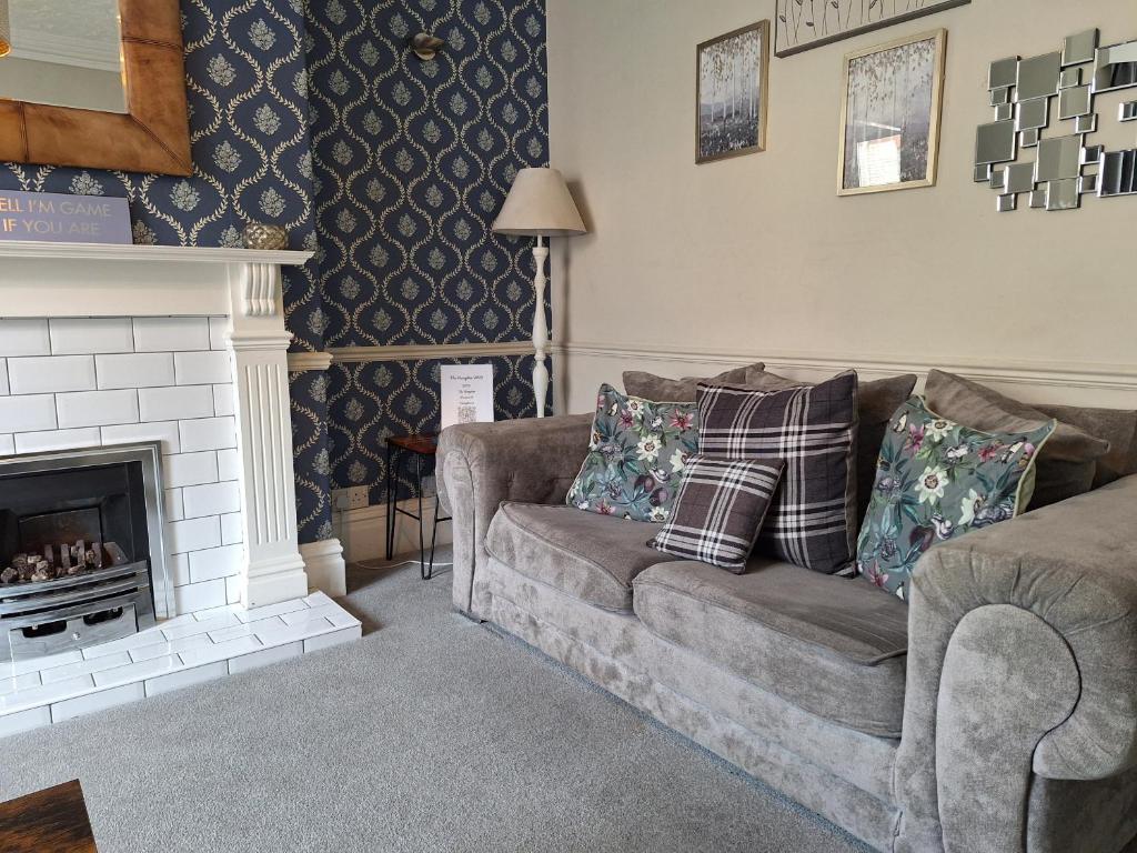 a living room with a couch and a fireplace at The Hampton Beautiful 3 Bedroom House with Conservatory & Garden in Scarborough