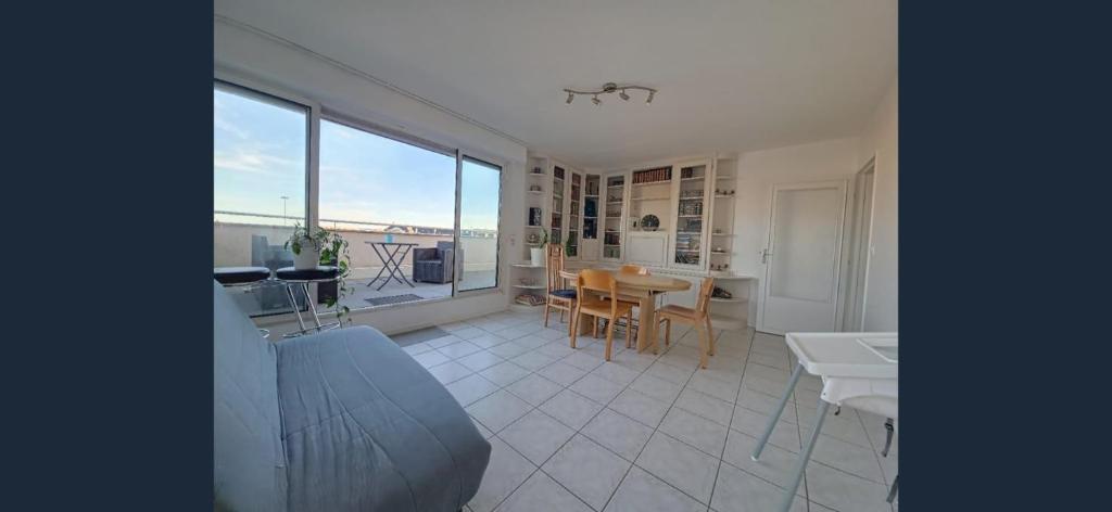a living room with a table and a kitchen with a view at Exceptional, 12 minutes RER C from Paris in Juvisy-sur-Orge