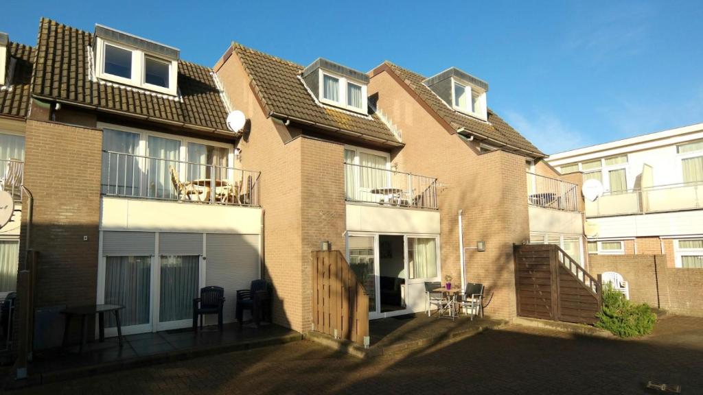 an apartment building with a balcony with chairs and a table at Appartement Boodtlaan 4E in De Koog