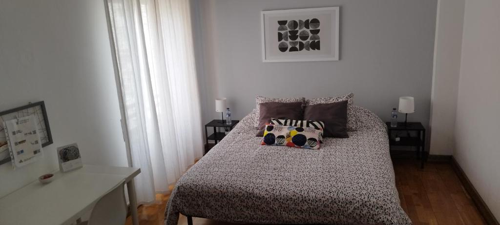 a small bedroom with a bed with two pillows at Vieira's House Suíte in Barreiro