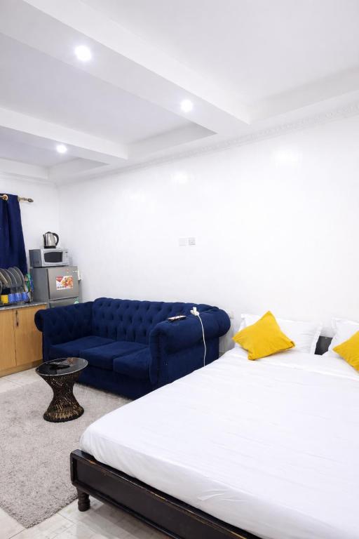 a bedroom with a large bed and a blue couch at Pivot Studio near Westside mall in Nakuru
