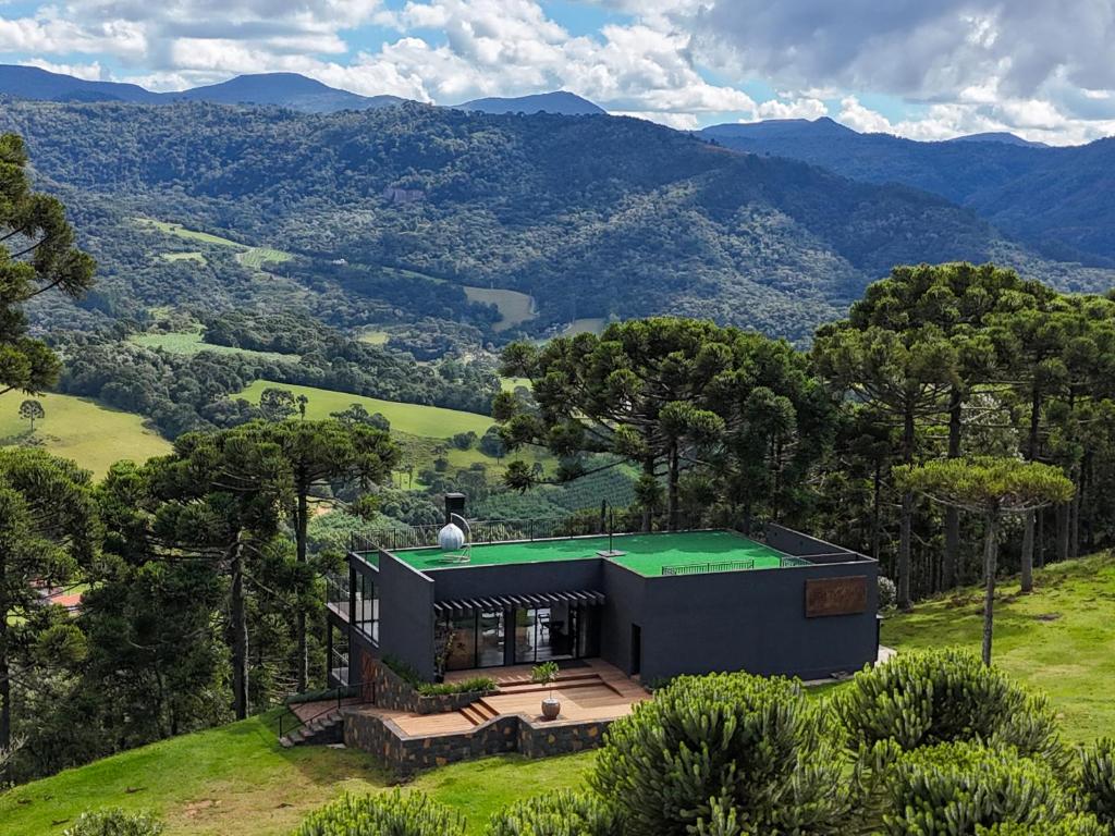 a house with a green roof on top of a hill at Mökki Cabanas de Altitude INAUGURAÇÃO ABRIL 2026 in Urubici