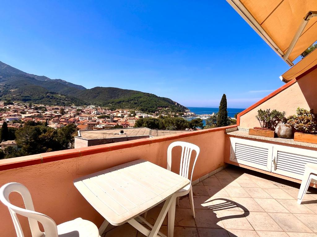 a white table and chairs on a balcony with a view at Le 3 case di Mia in Marciana Marina