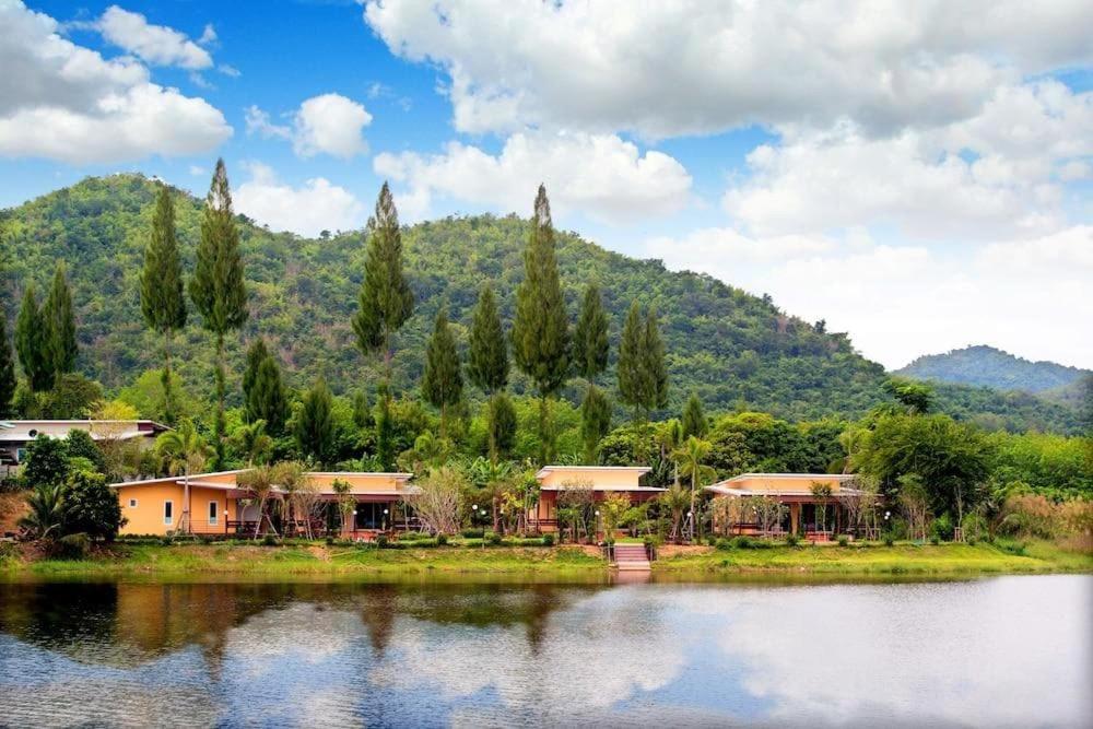 a group of houses next to a body of water at Social Escape Hotel Lemon Chalet in Ban Song Phi Nong