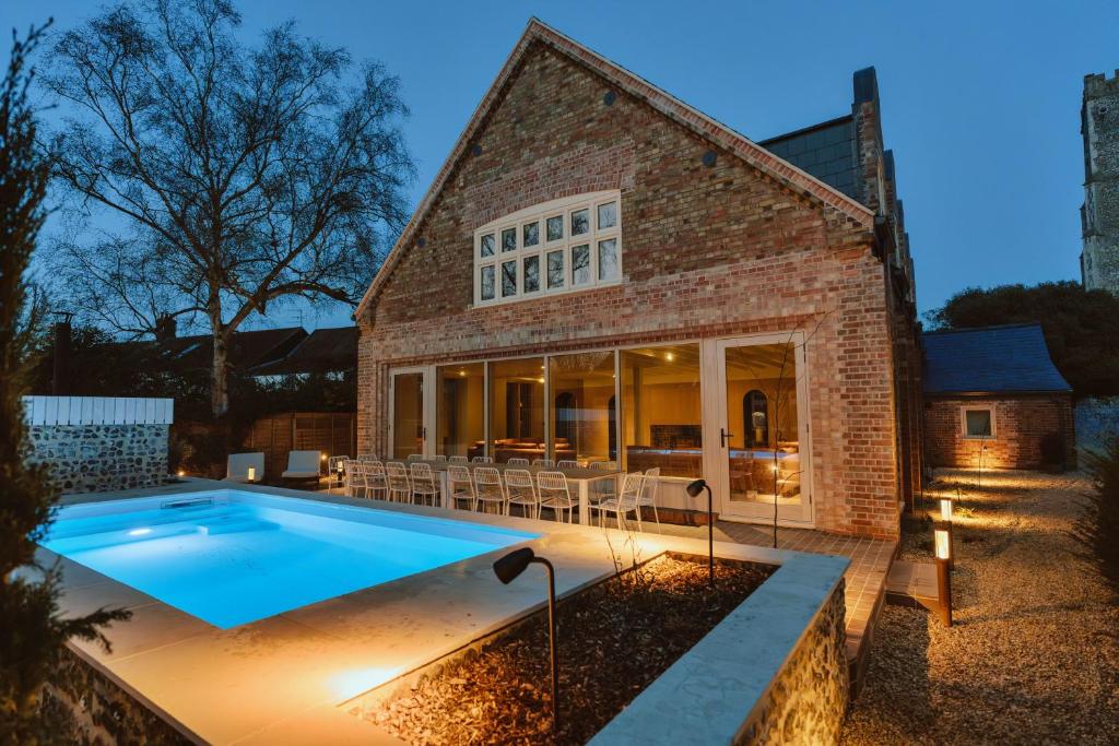 a brick house with a swimming pool in front of it at Finest Retreats - ARC Next-The-Sea in Wells next the Sea
