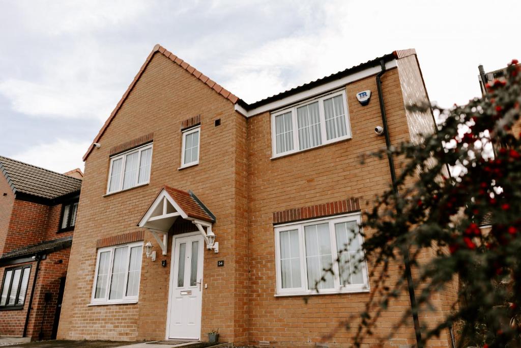 a brick house with a white door at Buckthorn Grove - 4 bed stunning home in Middlesbrough