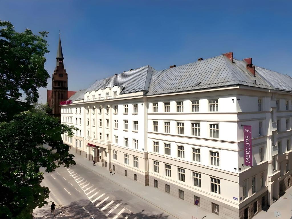 a white building with a clock tower in the background at Mercure Ostrava Center in Ostrava