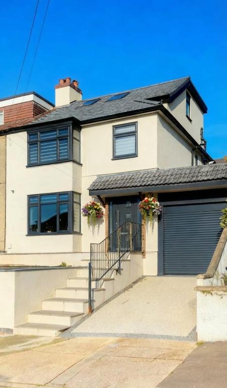 a white house with a gate and a garage at Lush Rooms Bedminster in Bristol