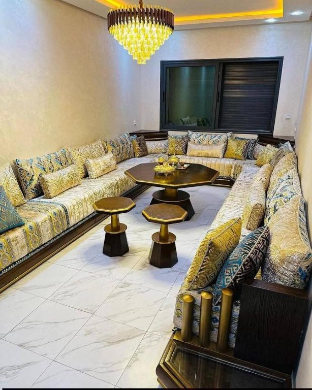 a living room with a large couch and a table at Moroccan Inspired 2BR Bright, Central & New in Oulad Akkou