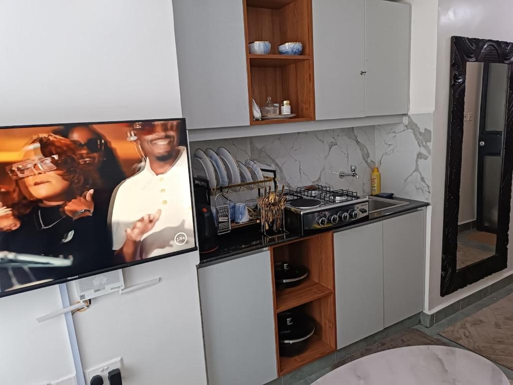 a kitchen with white cabinets and a stove at Cozy Studio Kiambu Town in Kiambu
