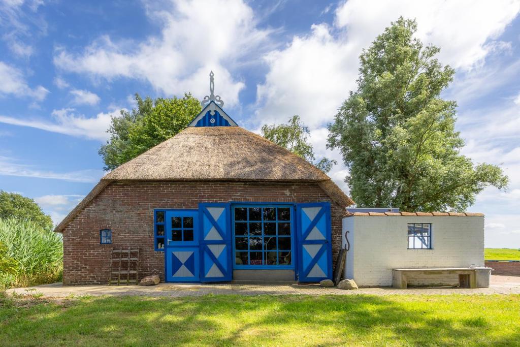 an old brick barn with a thatched roof at Olle Hansenhaus in Hantumeruitburen