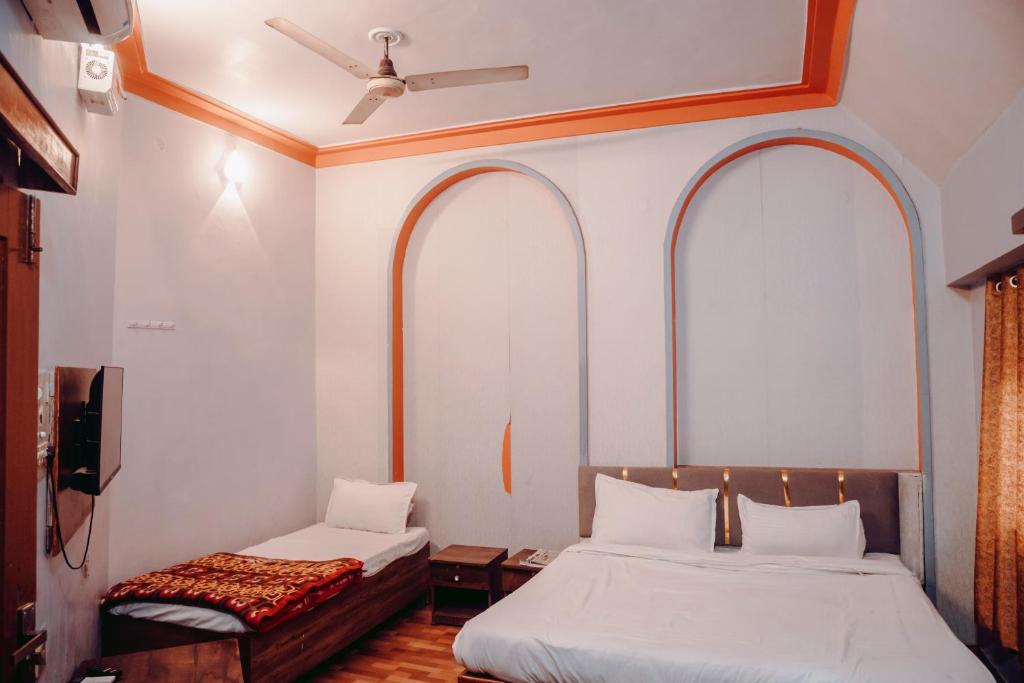 two beds in a room with two bedsskirts at Hotel The TWB palace in Gwalior