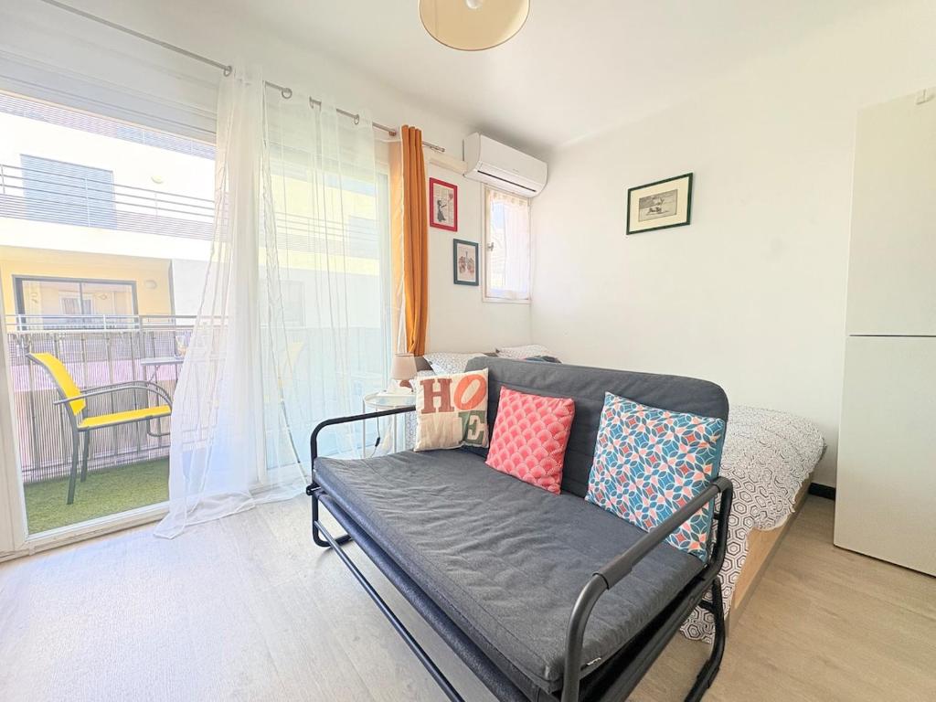 a living room with a couch and a window at Studio à Canet Plage 200m Mer Balcon in Canet-en-Roussillon