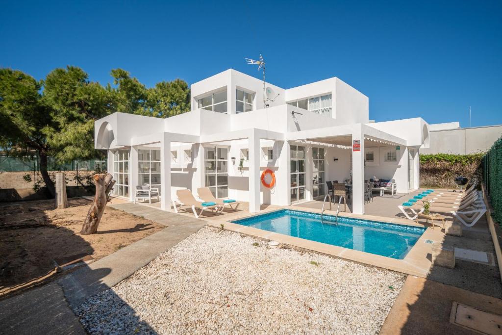 a white house with a swimming pool in front of it at Villa Savina by BeBreeze in Can Picafort