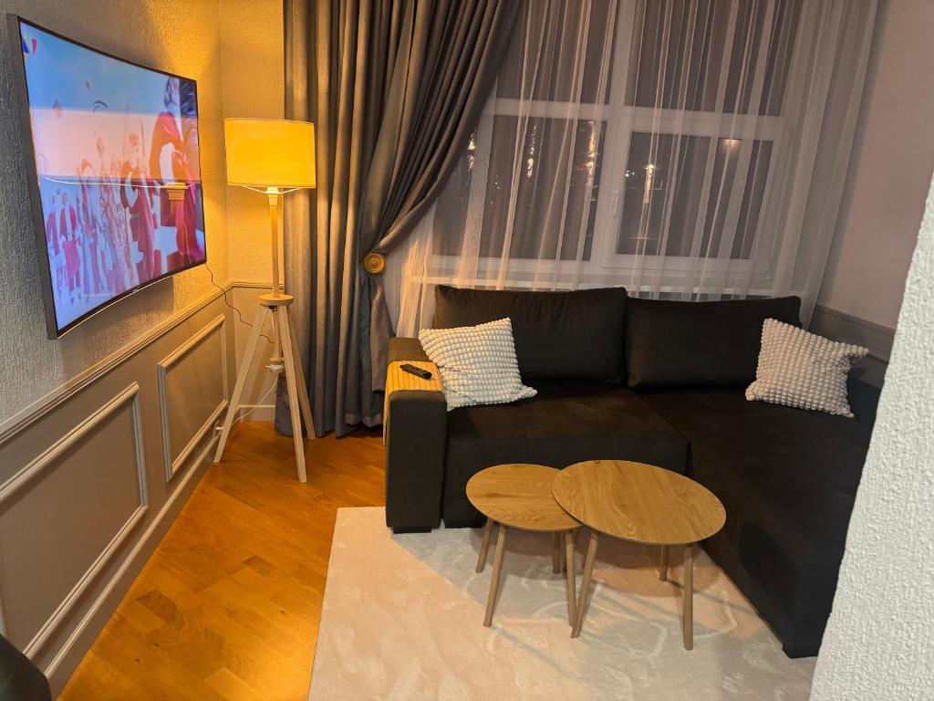 a living room with a black couch and a table at Inza in Druskininkai
