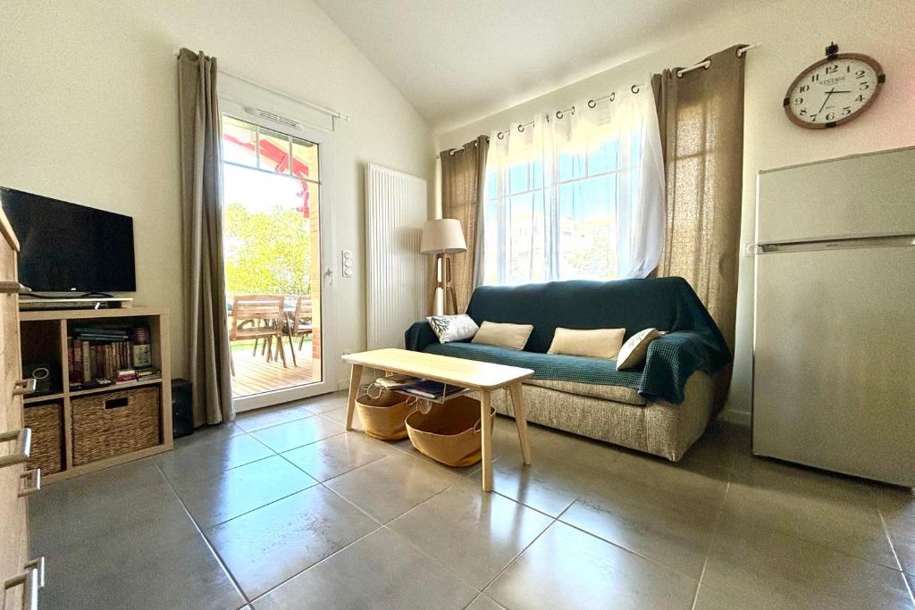 a living room with a couch and a table at Air-conditioned house in the Arcachon style with swimming pool in La Teste-de-Buch