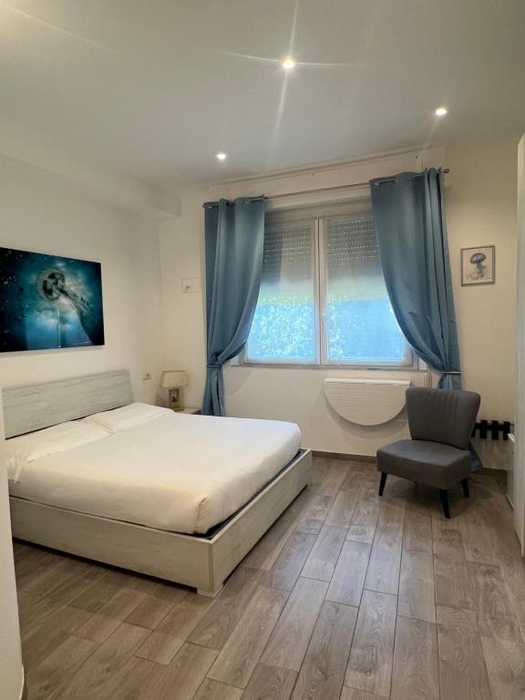 a bedroom with a bed and a chair and a window at Affittacamere Vallesanta in Levanto