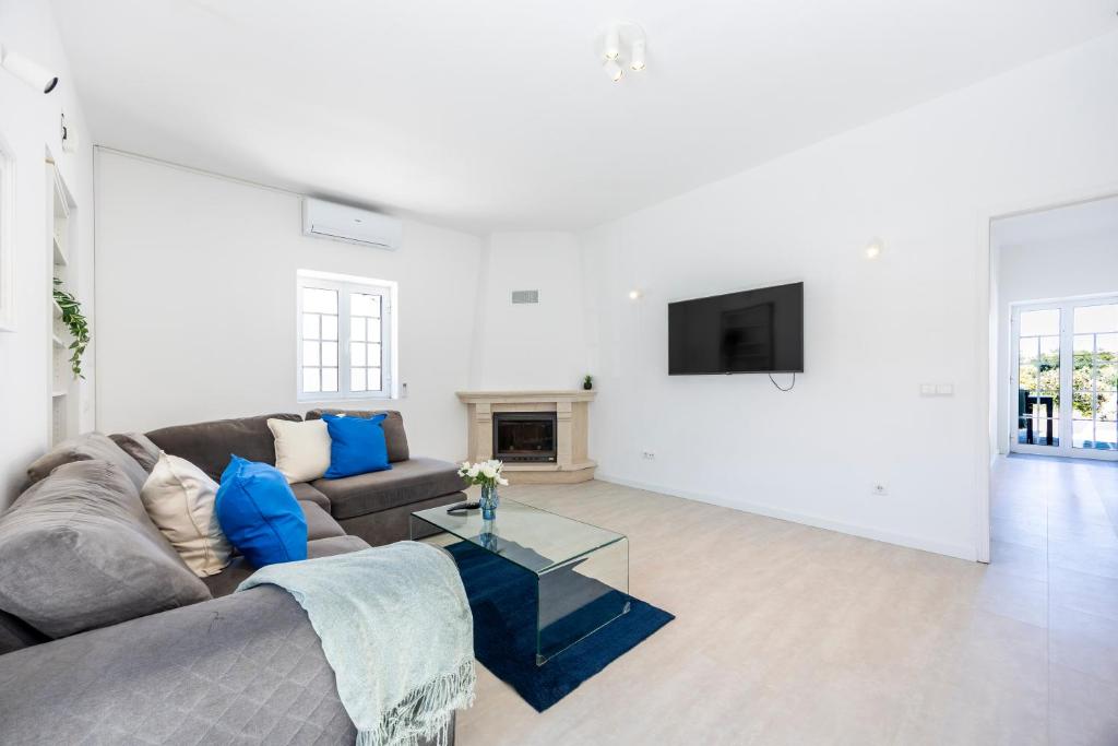a living room with a couch and a tv at Casa do Vale in Paderne