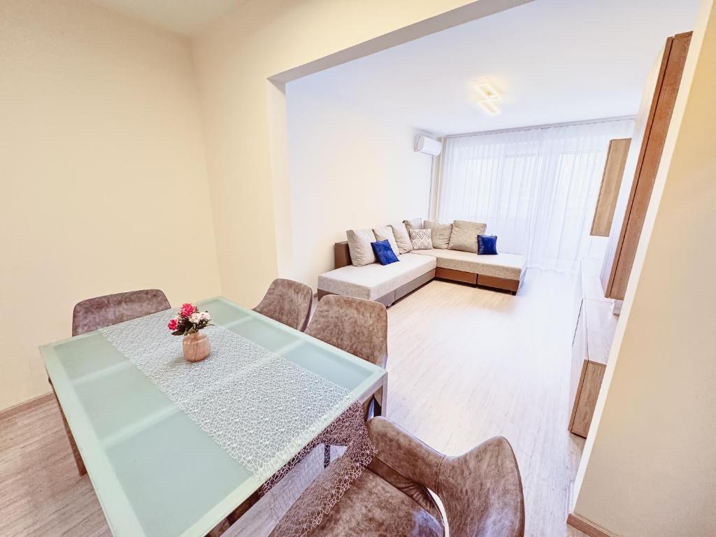 a dining room with a table and chairs and a couch at Kodó Apartman in Székesfehérvár