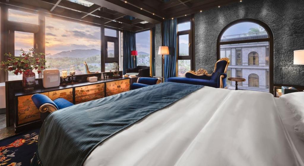 a bedroom with a large bed and large windows at Zishui Qinglu Manor in Sanya