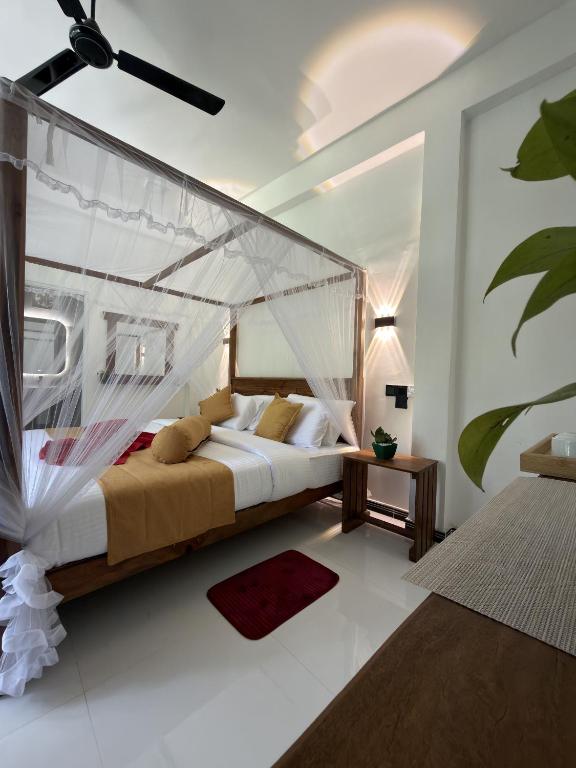 a bedroom with a bed with a mosquito net at Flower Resort Ella in Ella