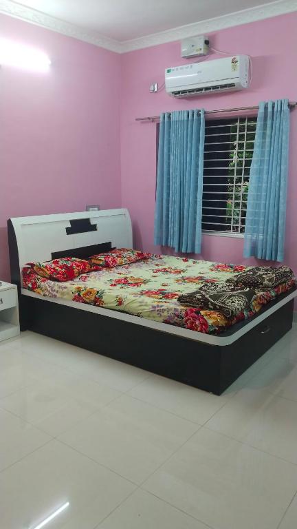 a bedroom with a bed in a pink room at Avani homestay in Subrahmanya