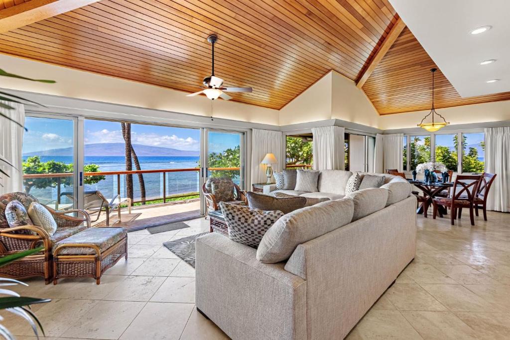 a living room with a large couch and a table at Puunoa Beach Estates 205 in Lahaina