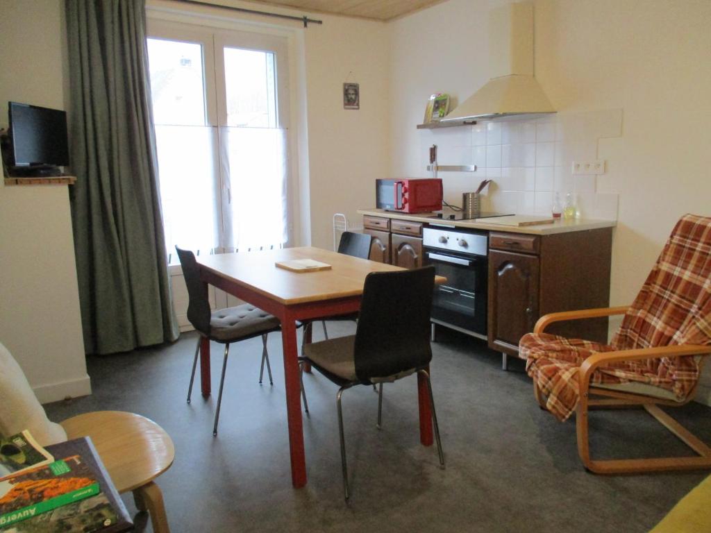 a kitchen with a table and chairs in a room at Gîte les Bois - 45 m2 in Orcival