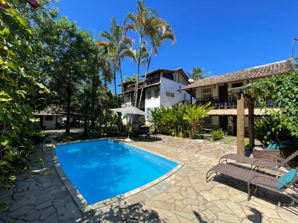 a swimming pool in front of a house at Atobá Villas in Paraty