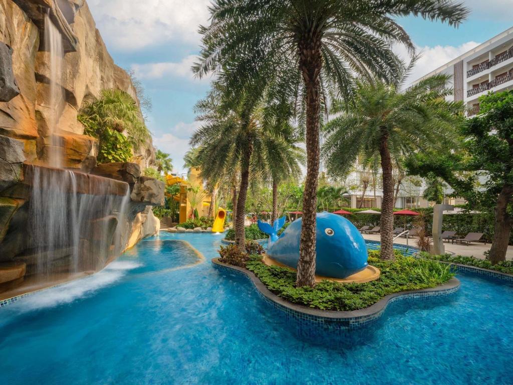 a water slide at a resort with palm trees at Mercure Pattaya Ocean Resort in Pattaya
