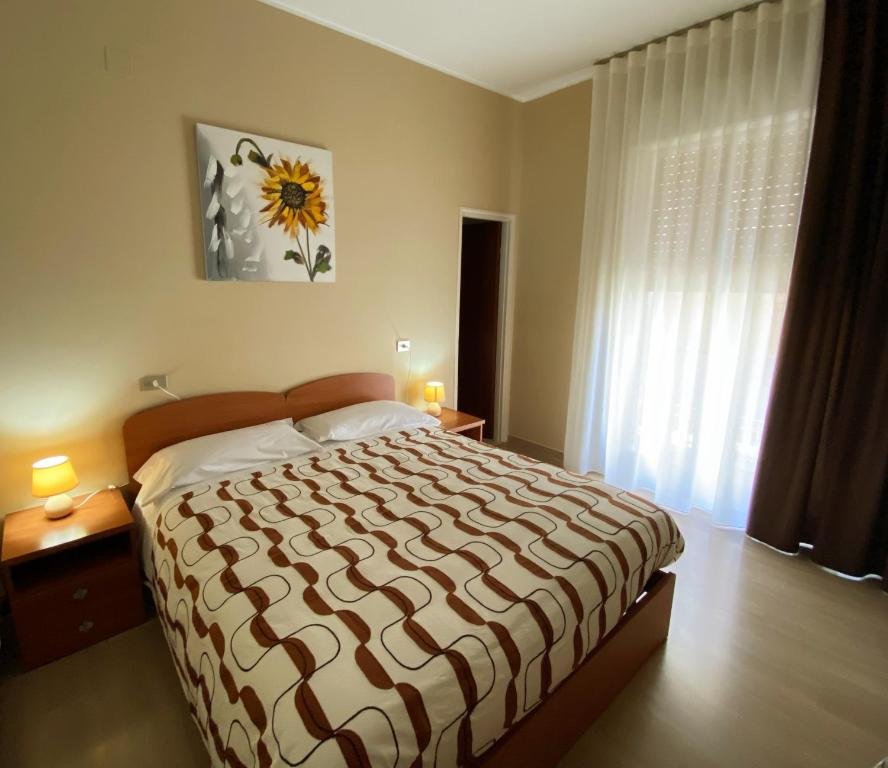 a bedroom with a large bed and a large window at Albergo Mendolia in Milazzo