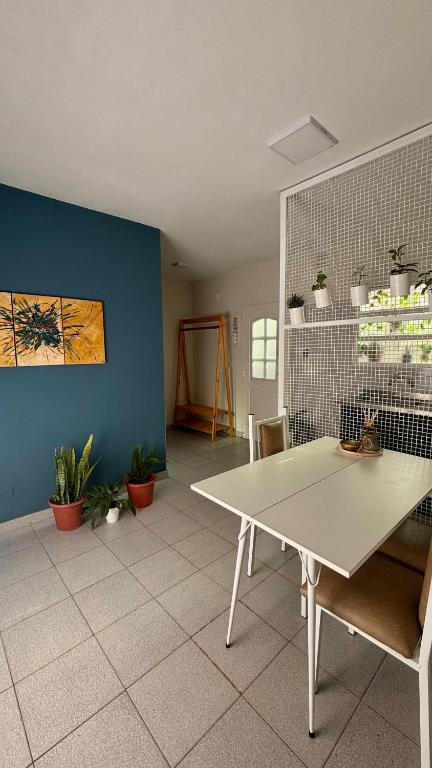 a dining room with a white table and a blue wall at La casita in Río Cuarto