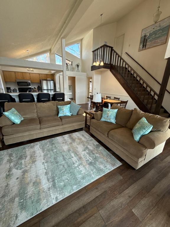 a living room with a couch and a staircase at Margarita Manor on Staniel Cay in Osage Beach