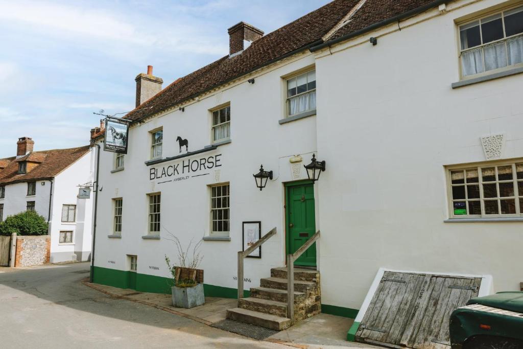 a white building with a green door at The Black Horse in Amberley