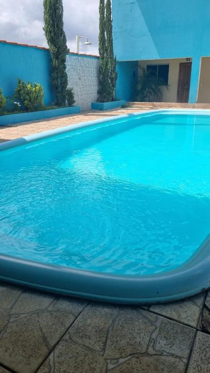 a large blue swimming pool in front of a building at Paulos Pousada in Lagoa Santa