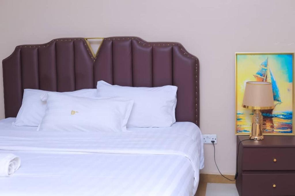 a bedroom with a large bed with white pillows at BUDDIEZ hotel limited in Kampala