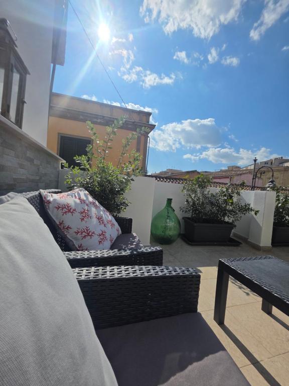 a patio with a couch and a table and some plants at Appartamento Dancardi in Quartu SantʼElena