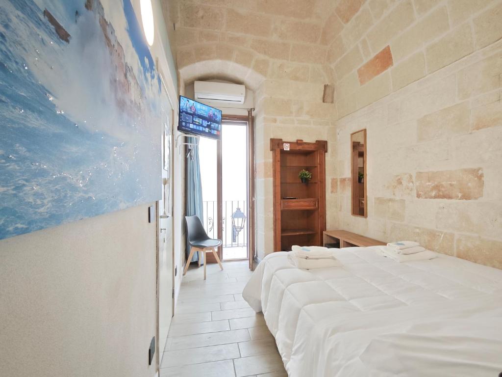 a bedroom with a bed and a tv on a wall at Azzurro A Mare in Polignano a Mare