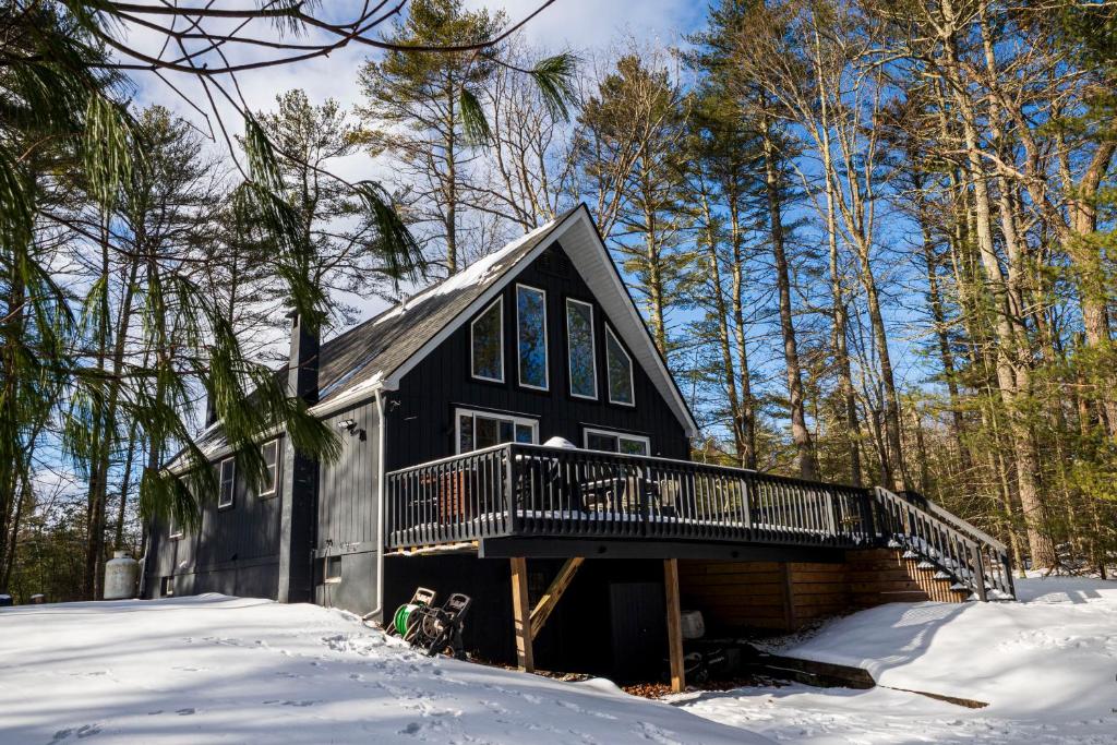 a black house with a deck in the snow at Private Fire Pit Pool Table Barry Manor in Barryville