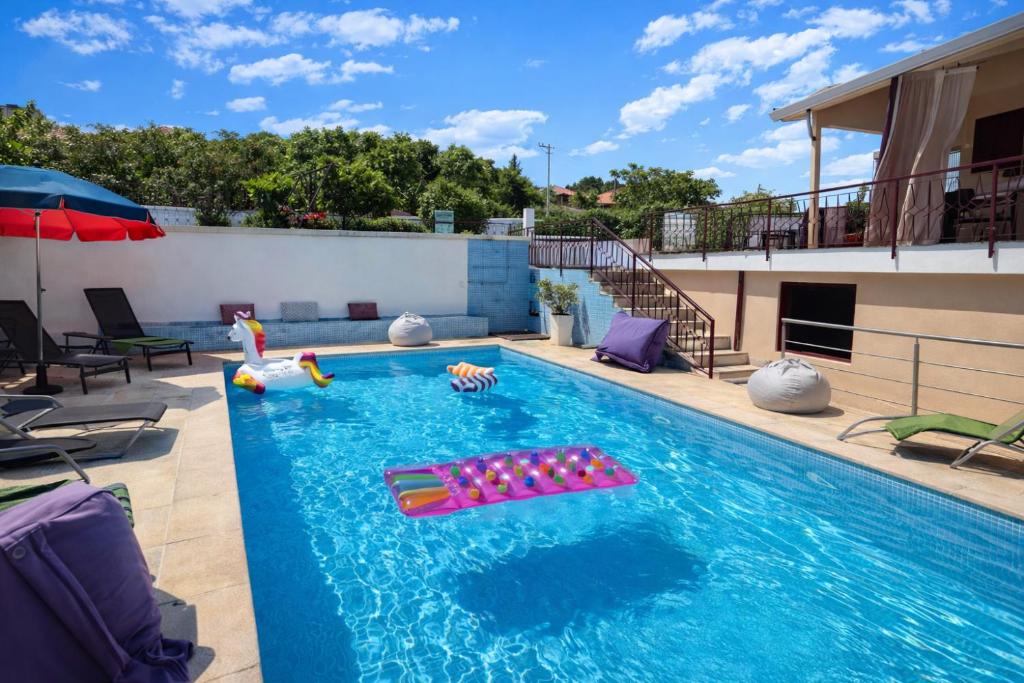 a swimming pool with chaise lounges and inflatables on a building at Villa Esteves avec piscine proche Braga Parking-terrasse & calme in Vila Verde