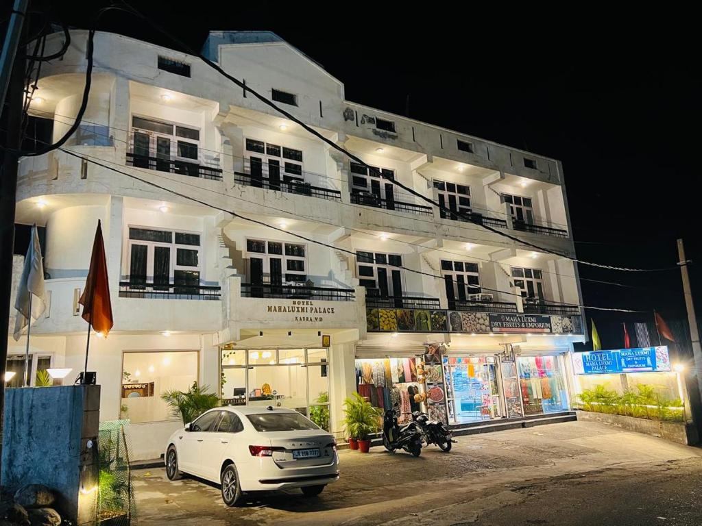 a white car parked in front of a building at Hotel Maha Luxmi Palace in Katra